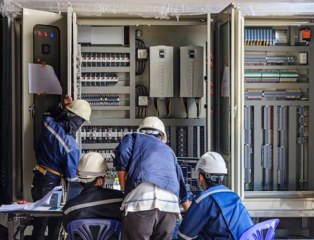 engineer-working-checking-maintenance-equipment-wiring-plc-cabinet_29285-1084